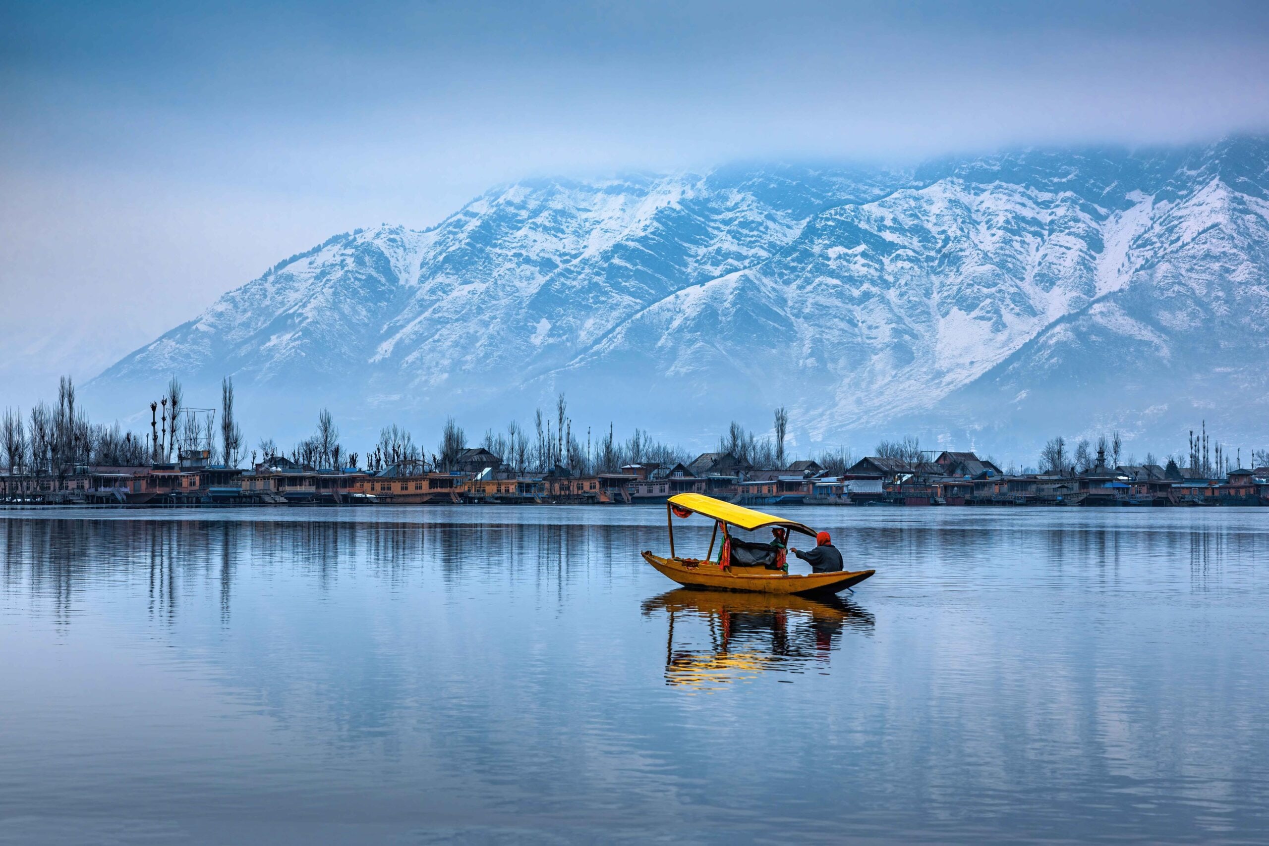 boat in a lake with snow-tipped mountains